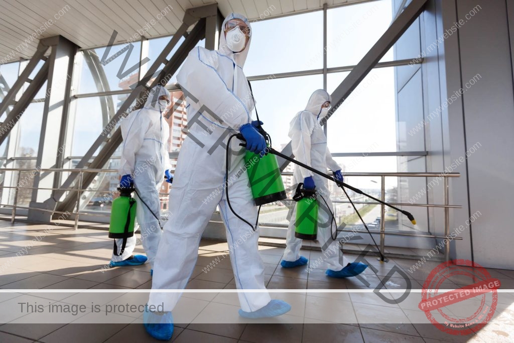 men in respirators and protective suits cleaning p RUFCBNG