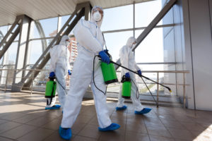 men in respirators and protective suits cleaning p RUFCBNG