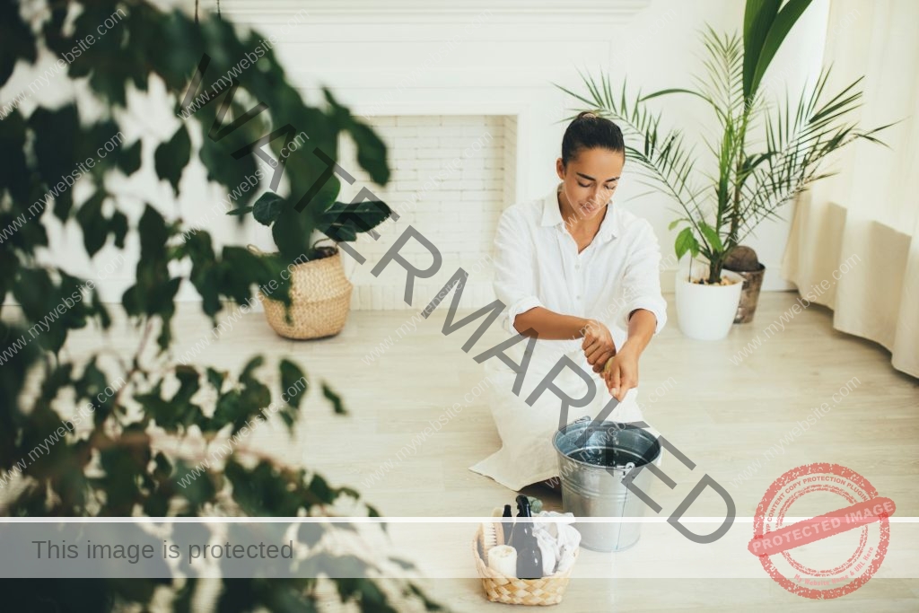 Woman washing floor using natural wooden eco friendly brush and fabric rag. Zero waste cleaning.