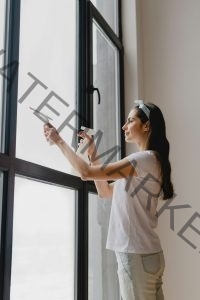 Young woman cleaning the window. Spring cleaning